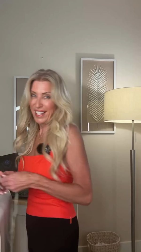 Erin Badour in a red dress smiling in a softly lit room